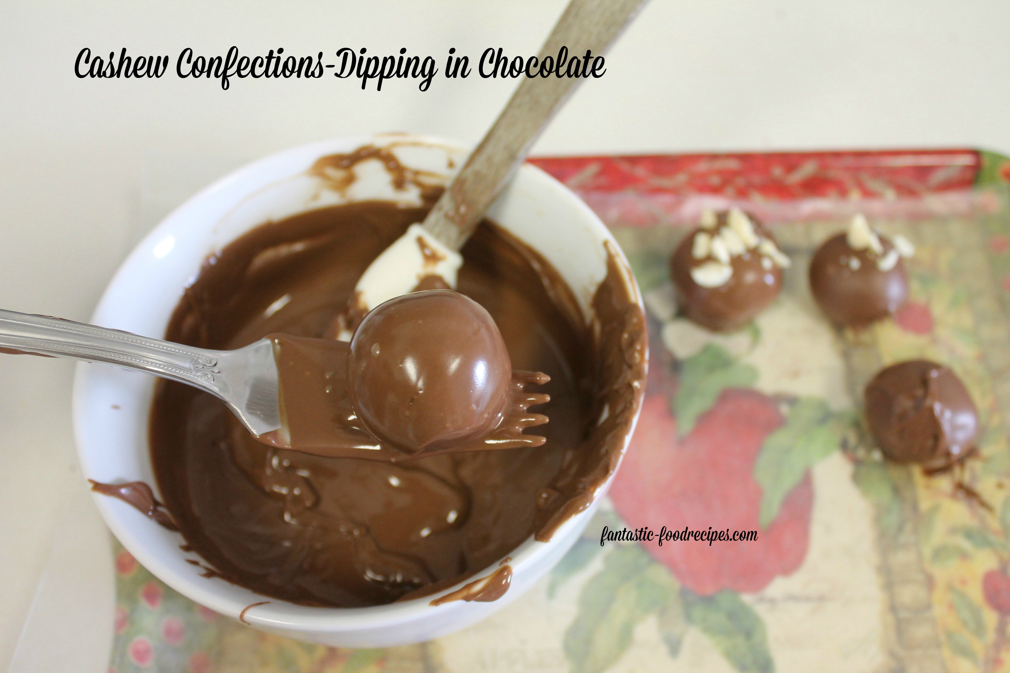 Cashew confections dip in chocolate using fork